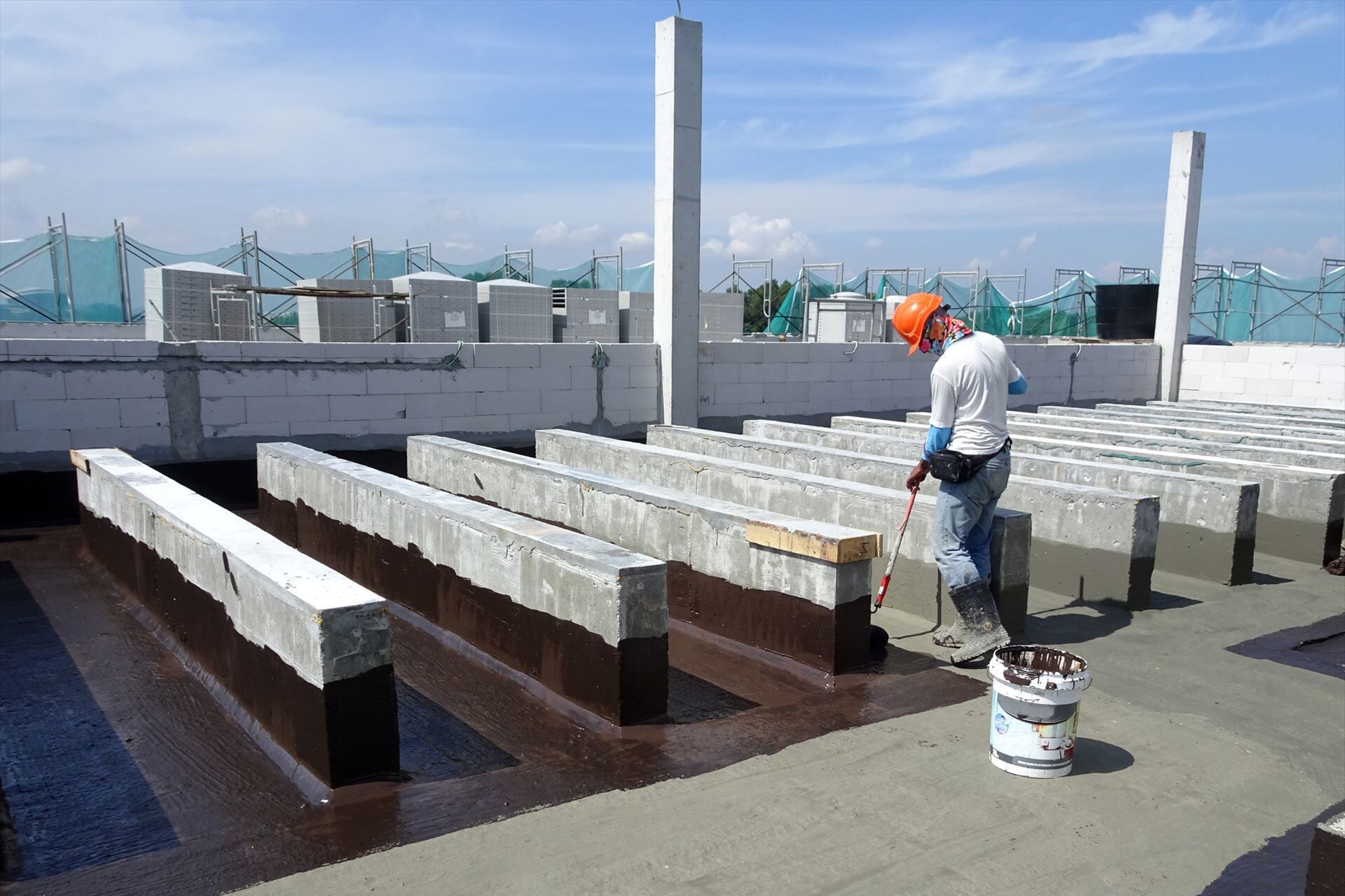 屋上の防水工事を行うスタッフ